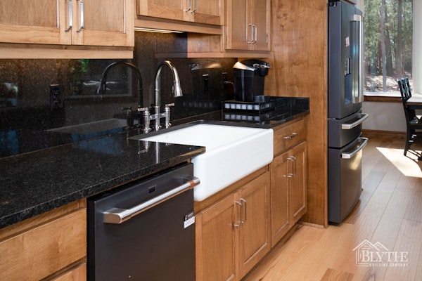 Stained Wood Kitchen Cabinets Black Granite Counter And Backsplash Black Appliances And White Farmhouse Sink 2