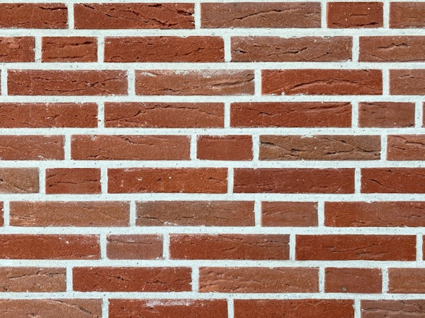 Brick wall with two sizes of bricks and flush mortar joint.
