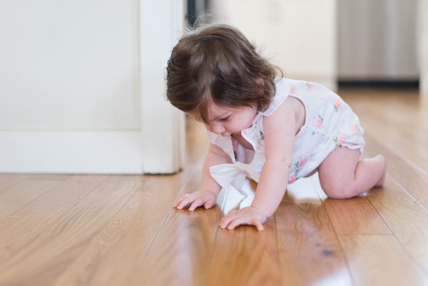 Baby girl crawling on wood floor - more comfortable with radiant floor heating