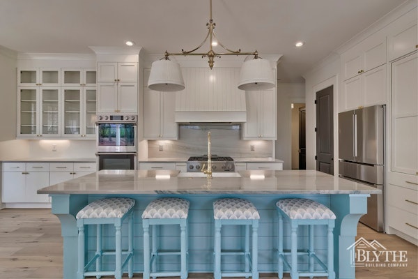Large Blue Kitchen Island With 4 Stools And White Cabinets With Custom Rangehood And Gas Stove