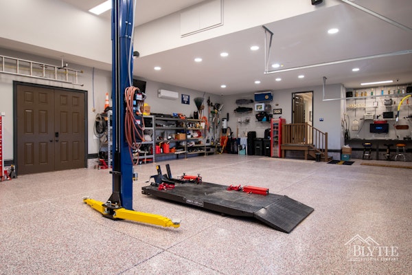 Custom Luxury Garage With Finished Floor Car Lift Vaulted Ceiling Computer Area And Car Building Equipment