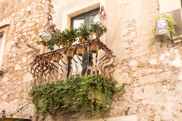 Italian Renaissance home with iron balcony and plants in Italy.