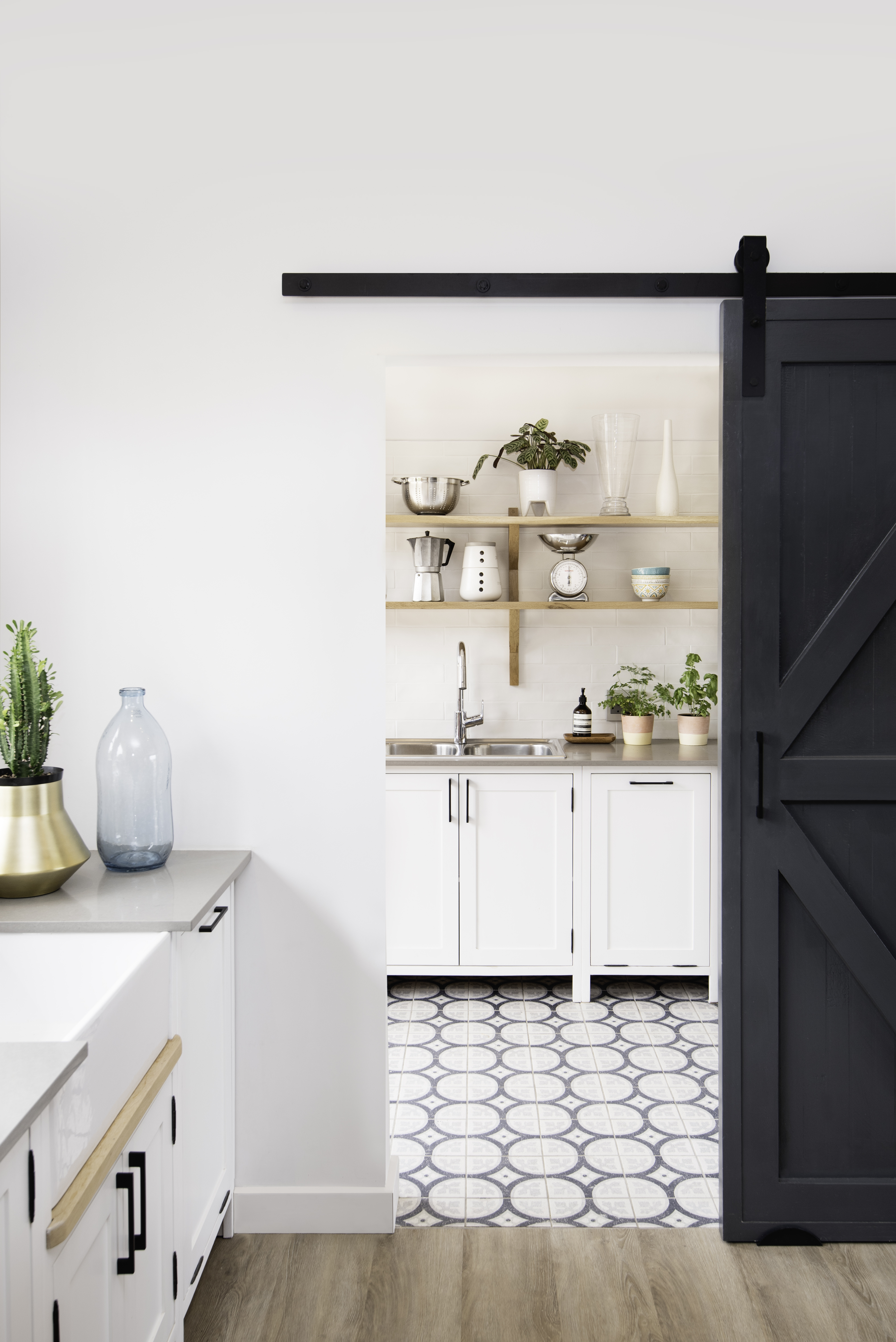 Kitchen in the foreground and a sliding barn door to a scullery in the background