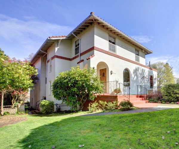 Spanish-Mediterranean style home with a stucco finish and red terra cotta roof.
