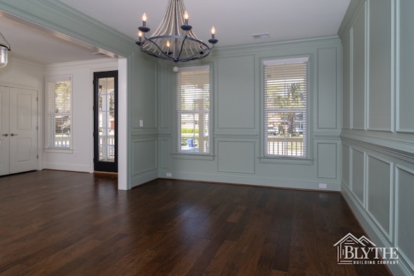 Dining Room With Full Wall Wainscoting Painted Green And Rustic Hardwood Floors 1