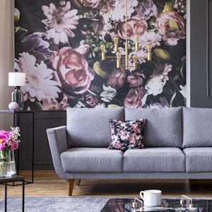 Maximalist design with wallpaper accent wall, couch, and throw pillow