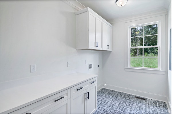 Custom Laundry Room With Patterned Tile Floors Custom Cabinets And Extra Counterspace