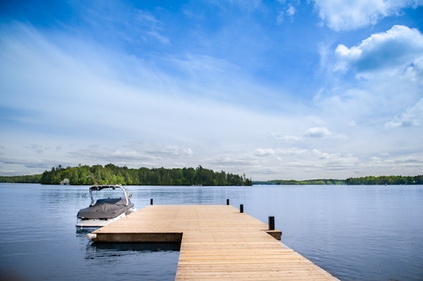 Boat dock on wide water on a lake with brilliant blue sky and clouds.