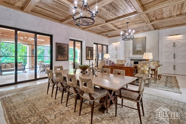 Elegant Living Space With Dining Area Living Room Custom Built Ins Covered By Beautiful Wood Doors A Gas Fireplace And Sliding Black Steel And Glass Doors To A Large Back Porch 1