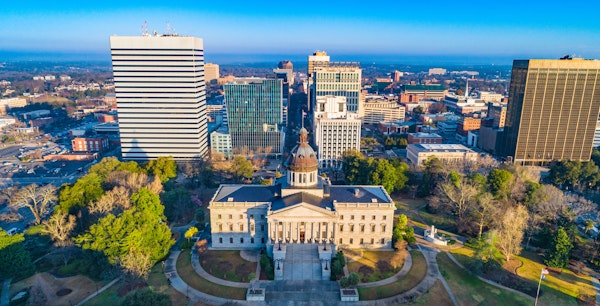 Aerial view of downtown Columbia, SC with the State House in the center looking down Main St.