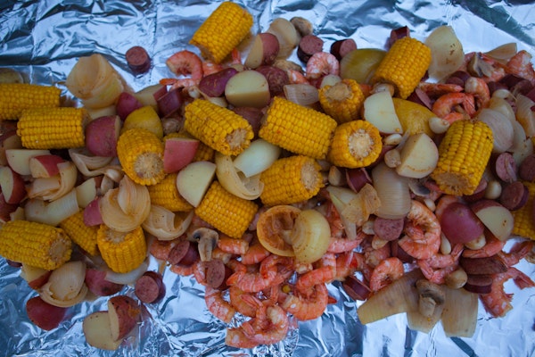 An overhead view of Frogmore stew/Lowcountry boil laid out on a table covered with aluminum foil