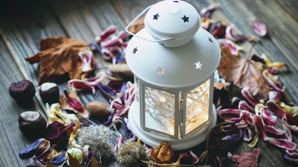 Holiday decorations with dried leaves and white lantern with fairy lights