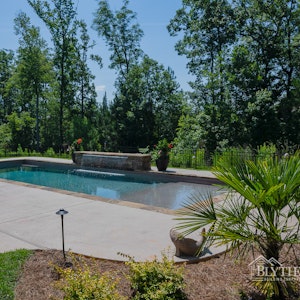 Large in-ground swimming pool with 8 ft long waterfall feature