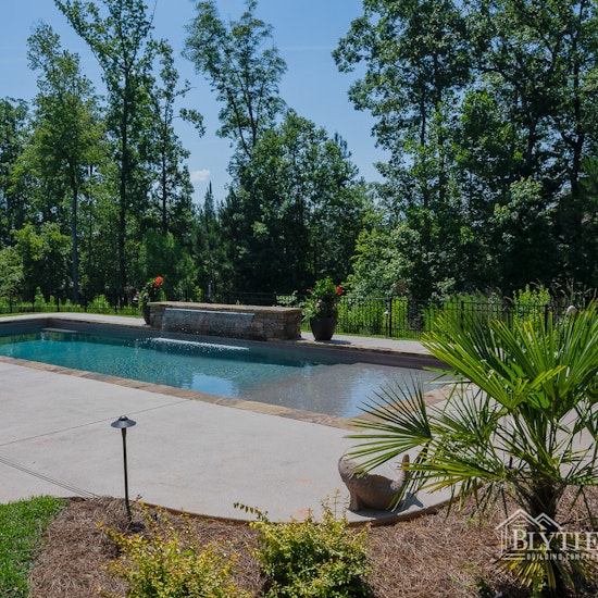 Large in-ground custom swimming pool with 8 ft long waterfall feature