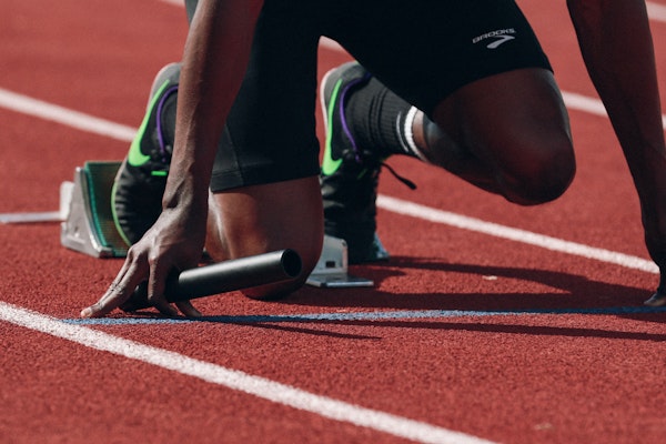 Close-up of runner's legs at starting blocks on track at a school
