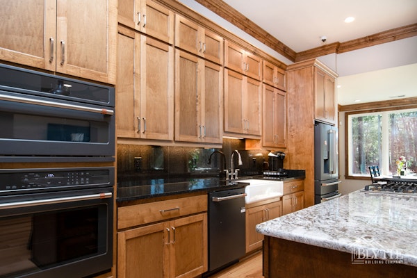 Custom Kitchen With Natural Wood Cabinets Picture Window Black Counters Black Appliances And Unique Kitchen Island 1