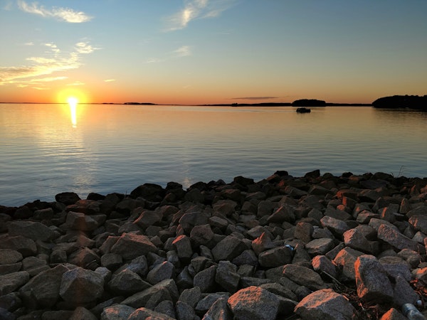 Sunset at Monticello Lake near Columbia, SC with large rocks along the shoreline.