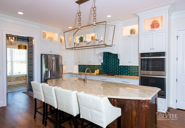 Custom shaker cabinets painted white with kitchen island with dark wood stain.