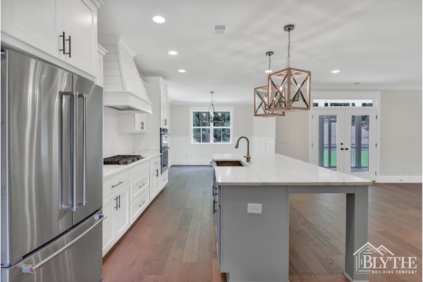 Large Eat In Kitchen Island With Oversized Pendant Lights And A Shiplap Range Hood
