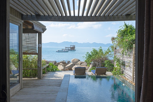 custom deck with pergola roof near water and mountains