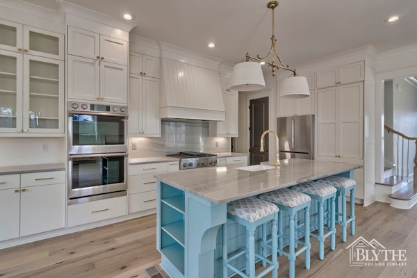 Custom Kitchen With Blue Kitchen Island With Eating Counter Stainless Steel Appliances Rustic Hardwood Floors And White Cabinets