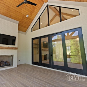 French Country Modern Back Porch With Vaulted Ceiling And Large Masonry Fireplace And White Painted Brick 