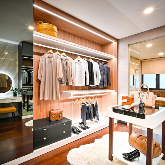 Luxury walk-in closet with contemporary mirror, vanity, and dressing table